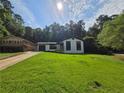 Charming renovated home with a freshly painted white brick exterior, dark trim, and a well-maintained green lawn at 2400 Glenrock Dr, Decatur, GA 30032