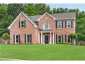 Charming brick two-story home with green lawn, dark shutters, and symmetrical window design at 260 Roberts Rd, Suwanee, GA 30024