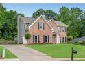 Brick two-story home with attached garage and lush green lawn in a suburban setting at 260 Roberts Rd, Suwanee, GA 30024