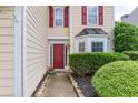 Close-up of the front door with a red door, a well-manicured front yard, and a bay window at 3514 Ethridge Nw Ln, Kennesaw, GA 30144