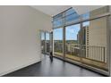 Bright room with access to balcony with views of the city skyline through expansive windows at 44 Peachtree Nw Pl # 2024, Atlanta, GA 30309
