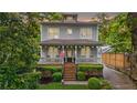 Inviting two-story home with a cozy front porch, adorned with an American flag and surrounded by lush greenery at 66 Mobile Ne Ave, Atlanta, GA 30305
