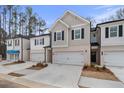 New townhomes with light colored brick, garages, and newly installed landscaping provide an inviting exterior at 504 Amethyst Way, Stockbridge, GA 30281