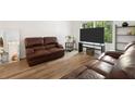 Open living room featuring hardwood floors, large mirror, and leather sofas at 3512 Lynview W Ct, Decatur, GA 30034