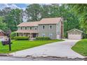 Inviting two-story home with a long driveway leading to a detached garage at 4826 Dean Sw Ln, Lilburn, GA 30047