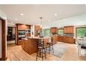 Bright kitchen features a large island with seating, stainless appliances, wood cabinets and wood flooring at 4826 Dean Sw Ln, Lilburn, GA 30047
