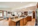 Open kitchen features a large island, wood cabinets, granite countertops, stainless steel appliances and dining area at 4826 Dean Sw Ln, Lilburn, GA 30047