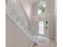 A bright foyer features a staircase with custom railing and a front door with decorative glass at 30 Stonewall Dr, Covington, GA 30016