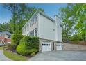 Side view of a two-story home with a three-car garage and well-maintained landscaping at 2987 Windward Nw Dr, Kennesaw, GA 30152