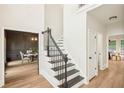 Open staircase with black railing leading to the upper level with views to the dining and breakfast areas at 2987 Windward Nw Dr, Kennesaw, GA 30152