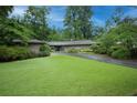Landscaped front yard with green grass and mature trees leading up to a single story home at 3353 Greenfield Dr, Marietta, GA 30068