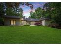 Expansive backyard with lush green lawn and established landscaping, ideal for outdoor activities at 140 Emily Sw Dr, Lilburn, GA 30047