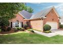 Beautifully maintained brick home showcasing lush greenery, a well-kept lawn, and charming curb appeal at 1887 Chamdun Pl, Brookhaven, GA 30341