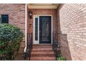 Close-up of the elegant front door, boasting a decorative glass panel and brick surroundings at 1887 Chamdun Pl, Brookhaven, GA 30341