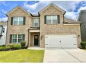 Inviting two-story home with a brick facade, landscaped yard, and a two-car garage at 1452 Weatherbrook Cir, Lawrenceville, GA 30043