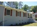 Side view of painted brick home with wood shutters and a screened porch at 2381 Eastway Rd, Decatur, GA 30033