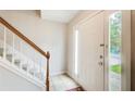 Bright entryway featuring tile flooring, a staircase with a wooden handrail, and a white front door at 3099 Regency Park Dr, Lithonia, GA 30038