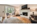 Bright living room with a stone fireplace, hardwood floors, bay window, and comfortable seating at 2336 Vistamont Dr, Decatur, GA 30033