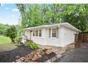 A side view of a charming, freshly painted home with stone walkway and meticulous landscaping at 3480 Mount Olive Rd, Atlanta, GA 30344