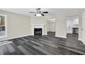 Inviting living room with a cozy fireplace, ceiling fan, and wood-look flooring at 3571 Kennesaw Station Nw Dr, Kennesaw, GA 30144