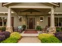 Inviting front porch with porch swing, rocking chair, and decorative rug and wall hangings at 525 E Main St, Buford, GA 30518