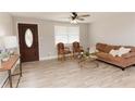 Inviting living room featuring new flooring, a stylish front door, and ample natural light from the large window at 6914 N Baggett Rd, Douglasville, GA 30134