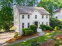 An elevated view of a white brick home showcasing its neatly landscaped yard and classic architectural details at 1590 Greyson Rdg, Marietta, GA 30062