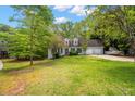 Charming single-Gathering home featuring dormer windows, a well-manicured lawn, and an attached two-car garage at 165 Colony Cir, Canton, GA 30114