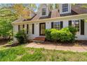 Well-maintained home with dormer windows, black shutters, and mature landscaping enhancing its curb appeal at 165 Colony Cir, Canton, GA 30114