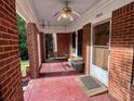 Inviting front porch featuring brick columns, swing, and ceiling fan at 3366 College St, College Park, GA 30337