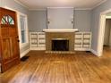 Bright living room with hardwood floors, a fireplace, and built-in shelves at 3366 College St, College Park, GA 30337