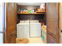 Functional laundry room with washer and dryer, featuring louvered doors and ample storage space for supplies at 1830 Brandy Se Ln, Conyers, GA 30013