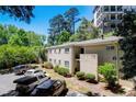 Apartment building with well-maintained landscaping and ample parking, nestled among mature trees at 311 Peachtree Hills Ne Ave # 10C, Atlanta, GA 30305