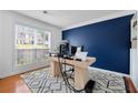 Bright home office featuring a large window, modern desk, and a bold accent wall at 6034 Farmwood Se Way, Mableton, GA 30126
