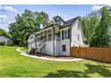 Side view of a beautiful home featuring a manicured lawn and a wooden fence at 1384 Sunrise Way, Lawrenceville, GA 30046