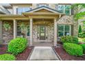 Inviting front porch with stone accents, decorative plants, and a welcoming entryway at 3230 Sundew Nw Dr, Acworth, GA 30101