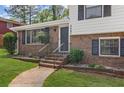 Inviting front entrance with brick facade, black shutters, and a well-manicured lawn at 6997 Vesta Brook Dr, Morrow, GA 30260