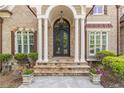 Elegant front entrance with stone steps, columns, and a wrought-iron double door at 1584 Water Springs Way, Dacula, GA 30019