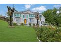 Beautiful two-story home with vibrant green shutters, a manicured lawn, and lush landscaping at 6031 Hitt Lake Ct, Stone Mountain, GA 30087