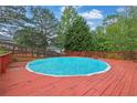 Inviting outdoor swimming pool surrounded by a red wooden deck at 6031 Hitt Lake Ct, Stone Mountain, GA 30087