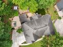 Aerial view of a home with a spacious backyard featuring a patio, hot tub, and lush landscaping at 10000 Groomsbridge Rd, Johns Creek, GA 30022