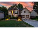 Twilight view of a two-story home with brick and siding under a colorful sky at 6217 Millstone Trl, Douglasville, GA 30135