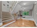 Inviting foyer featuring hardwood floors, a carpeted staircase, and a view into the living room at 6217 Millstone Trl, Douglasville, GA 30135