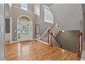 Bright foyer featuring gleaming wood floors, a staircase, and an arched doorway at 6217 Millstone Trl, Douglasville, GA 30135