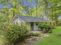 Home in a forest setting featuring a deck, a small backyard garden, and side entry at 6650 Bobby John Rd, Atlanta, GA 30349