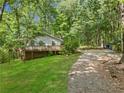 View of house with a nice yard, side deck, and long gravel driveway at 6650 Bobby John Rd, Atlanta, GA 30349