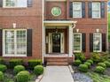 Charming brick home featuring a covered front porch and manicured landscaping at 790 Sienna Dr, Cumming, GA 30040