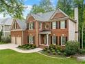 A beautiful brick home shows a manicured green lawn, landscaping, and traditional architectural details at 790 Sienna Dr, Cumming, GA 30040