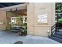 Building entrance at 905 Juniper with glass doors, stone facade, and well-maintained landscaping at 905 Juniper Ne St # 808, Atlanta, GA 30309