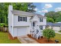Two-story home with garage, white siding, black shutters, and landscaped yard at 1645 Cobbs Creek Ln, Decatur, GA 30032